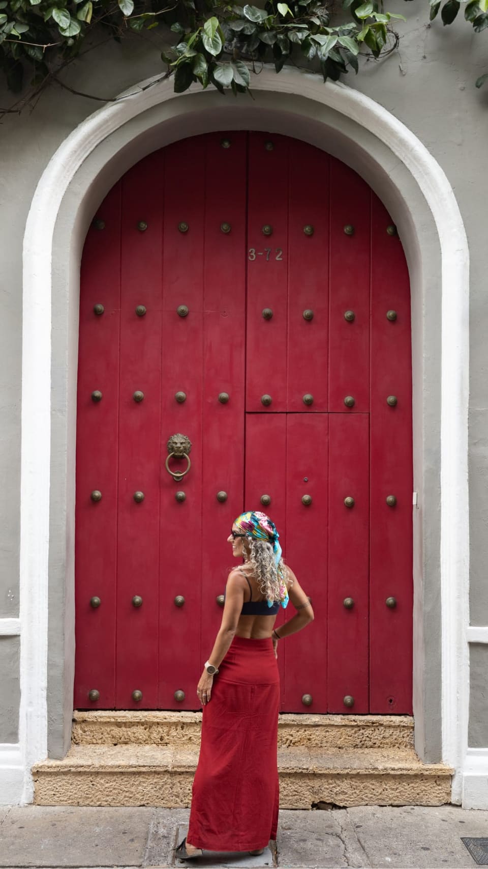 Viajante diante de uma porta colonial vermelha no centro histórico de Cartagena