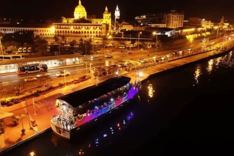 Barco iluminado navegando pela baía de Cartagena à noite