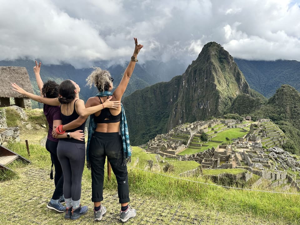 Viajantes comemorando com Machu Picchu ao fundo