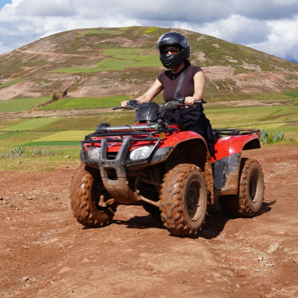 Viajante pilotando quadriciclo em estrada de terra vermelha