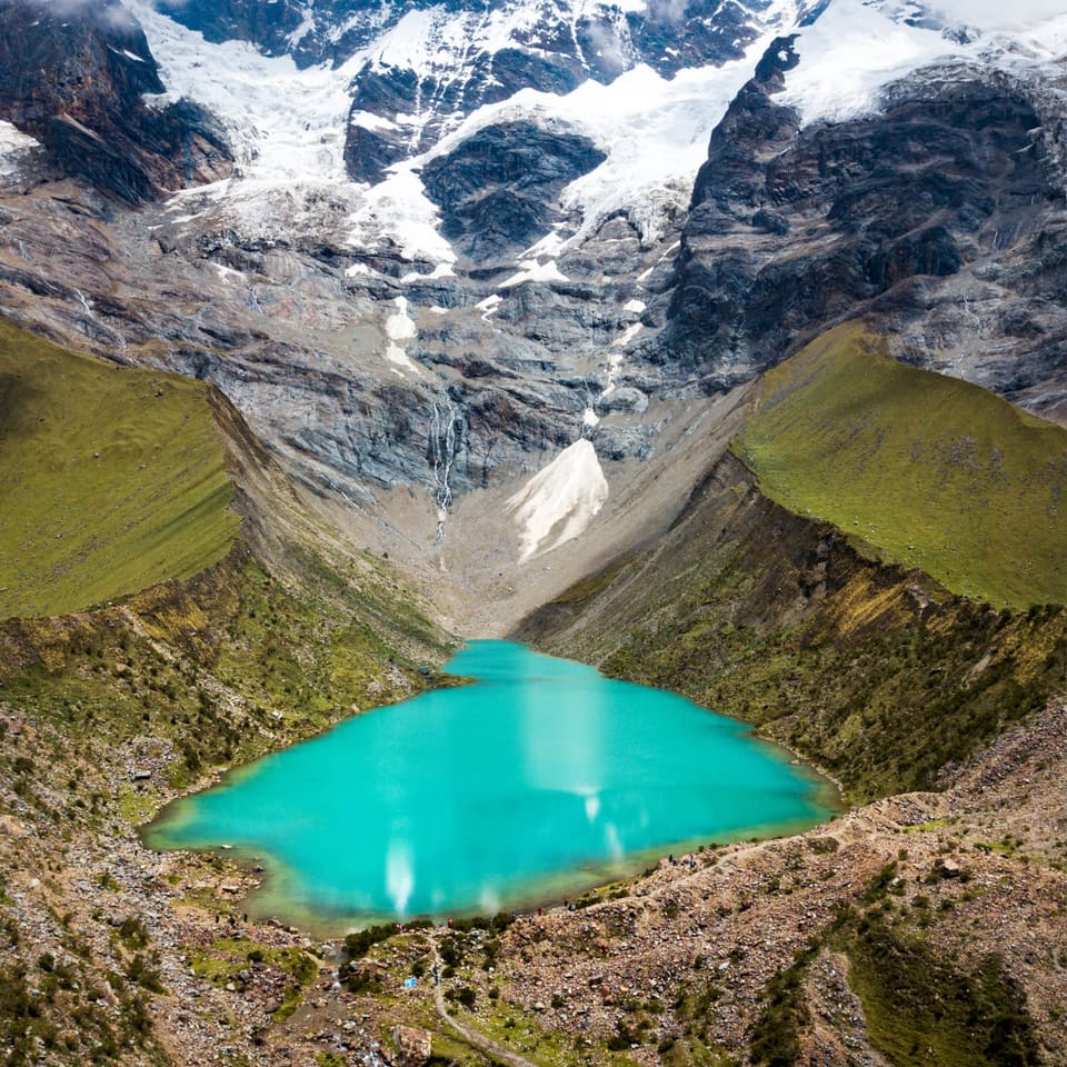 Laguna Humantay turquesa aos pés da montanha nevada