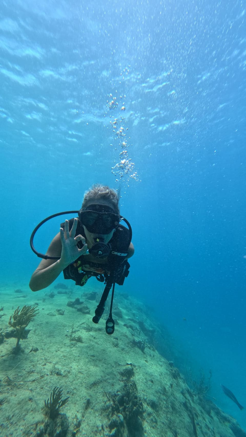 Mergulhador fazendo sinal de ok no fundo do mar azul de San Andrés