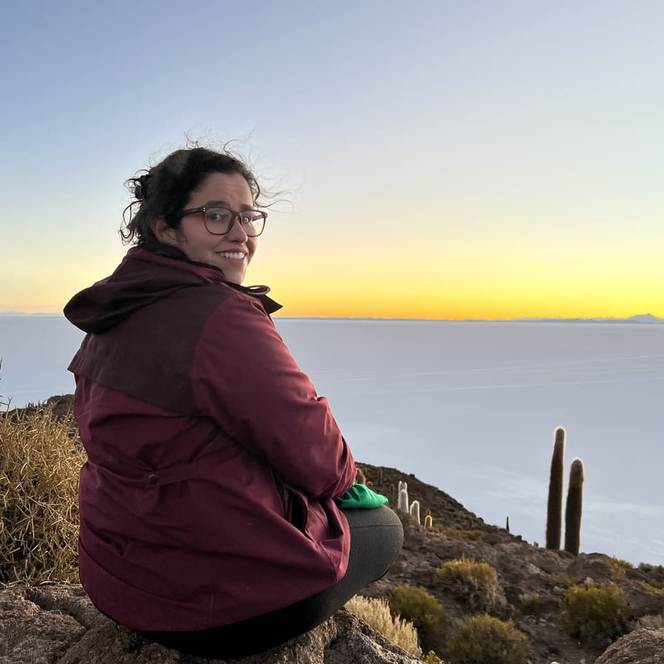 Viajante sentada diante do salar ao amanhecer