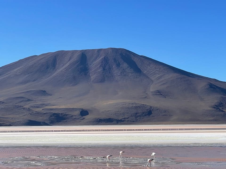Vulcão e salar sob céu azul